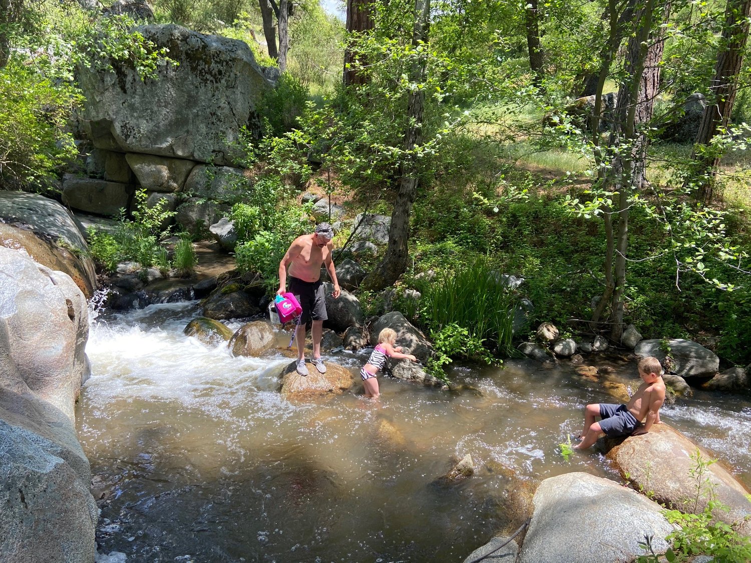 Family playing in the creek